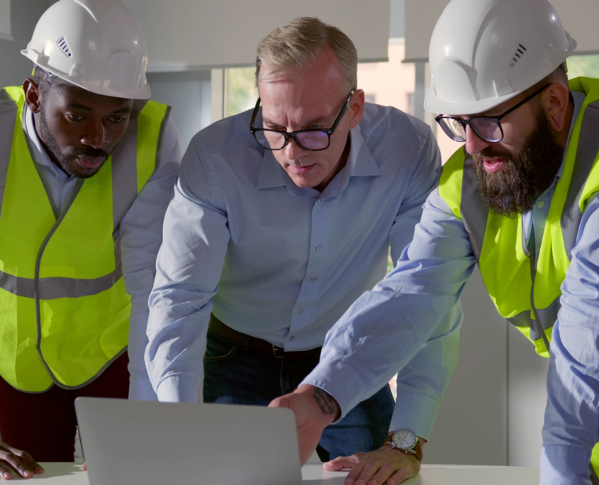 Construction Workers And Engineers Looking At Computer