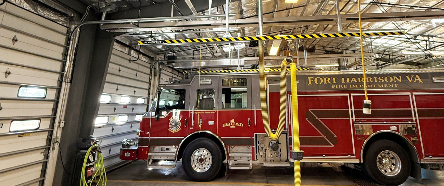 A fire truck is parked inside of a large garage.