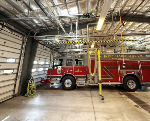 A fire truck is parked inside of a large garage.